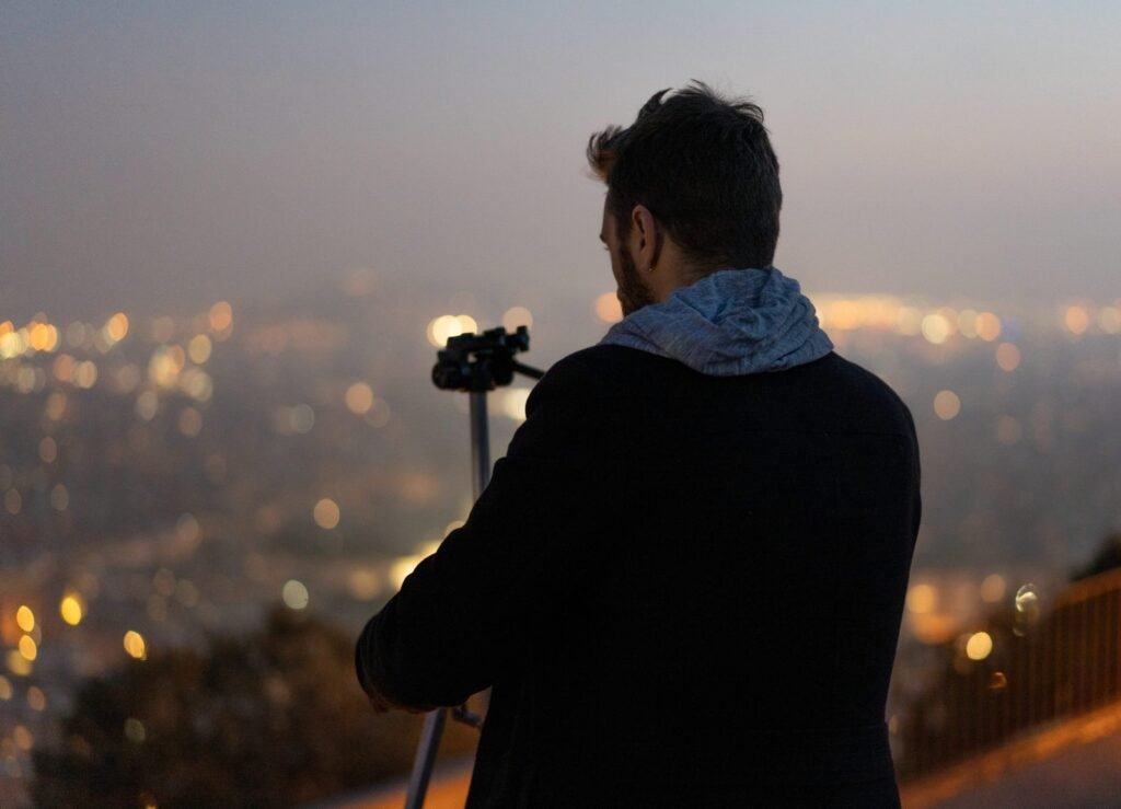 Nacho Menéndez, de espaldas, fotografía Barcelona al anochecer desde un mirador
